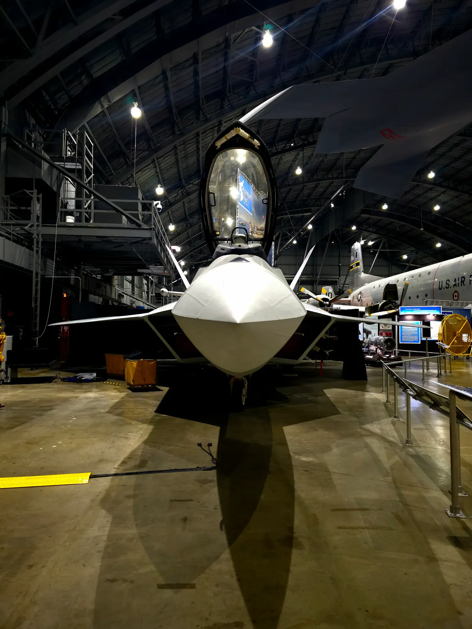 F-22 aircraft photographed head-on beneath museum lighting