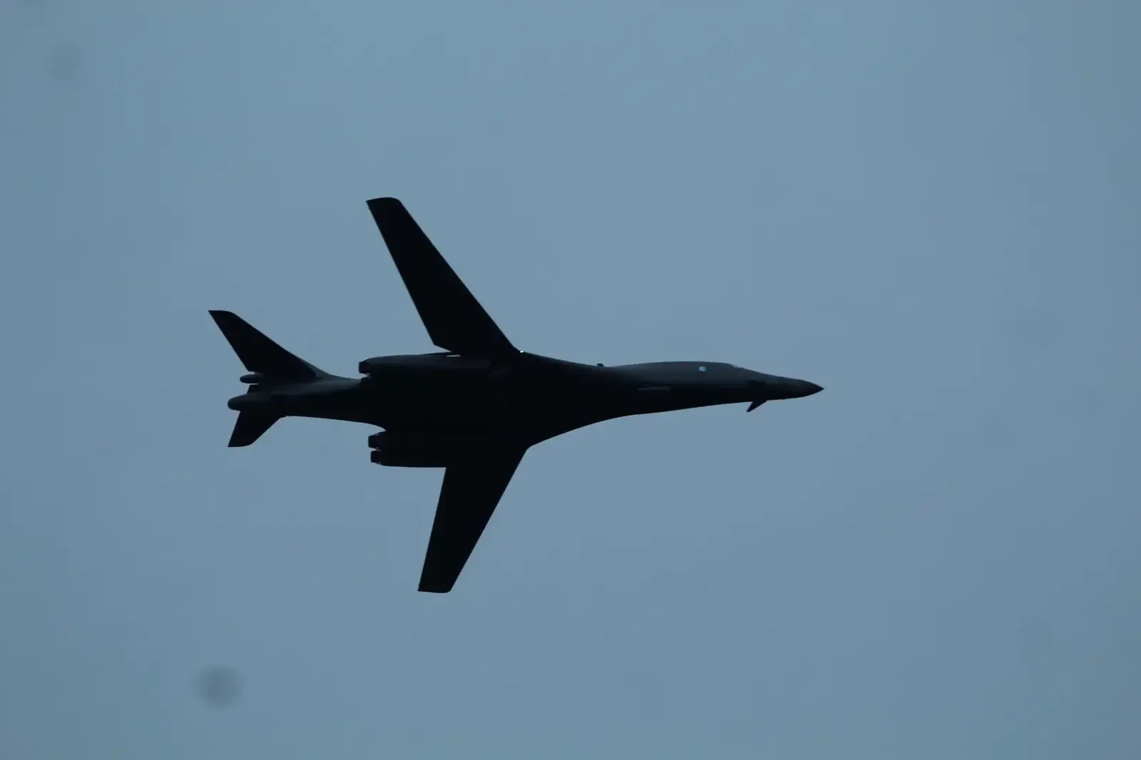 B-1B Lancer silhouetted while flying overhead