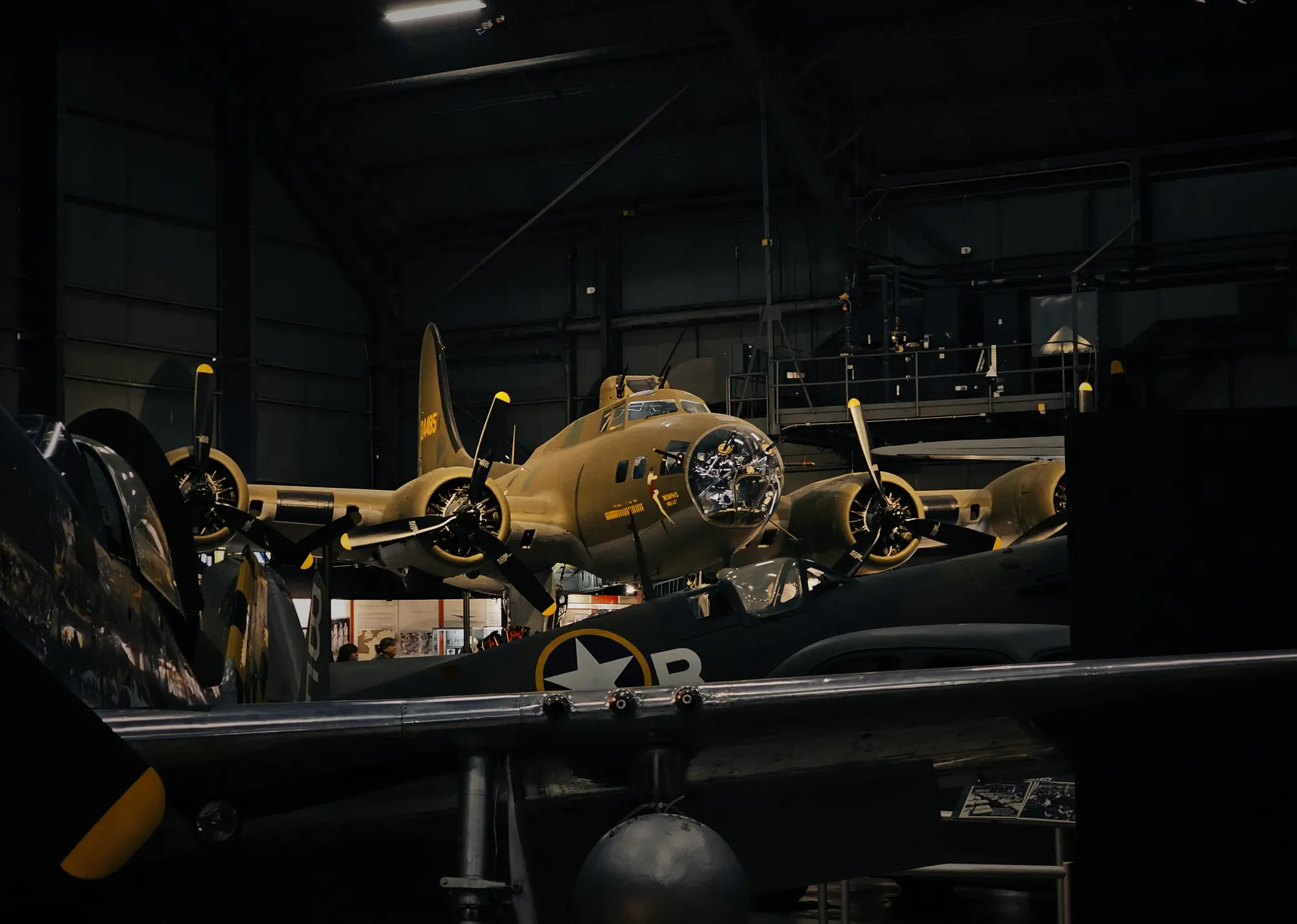 Historic multi-engine aircraft displayed in a dark museum hangar