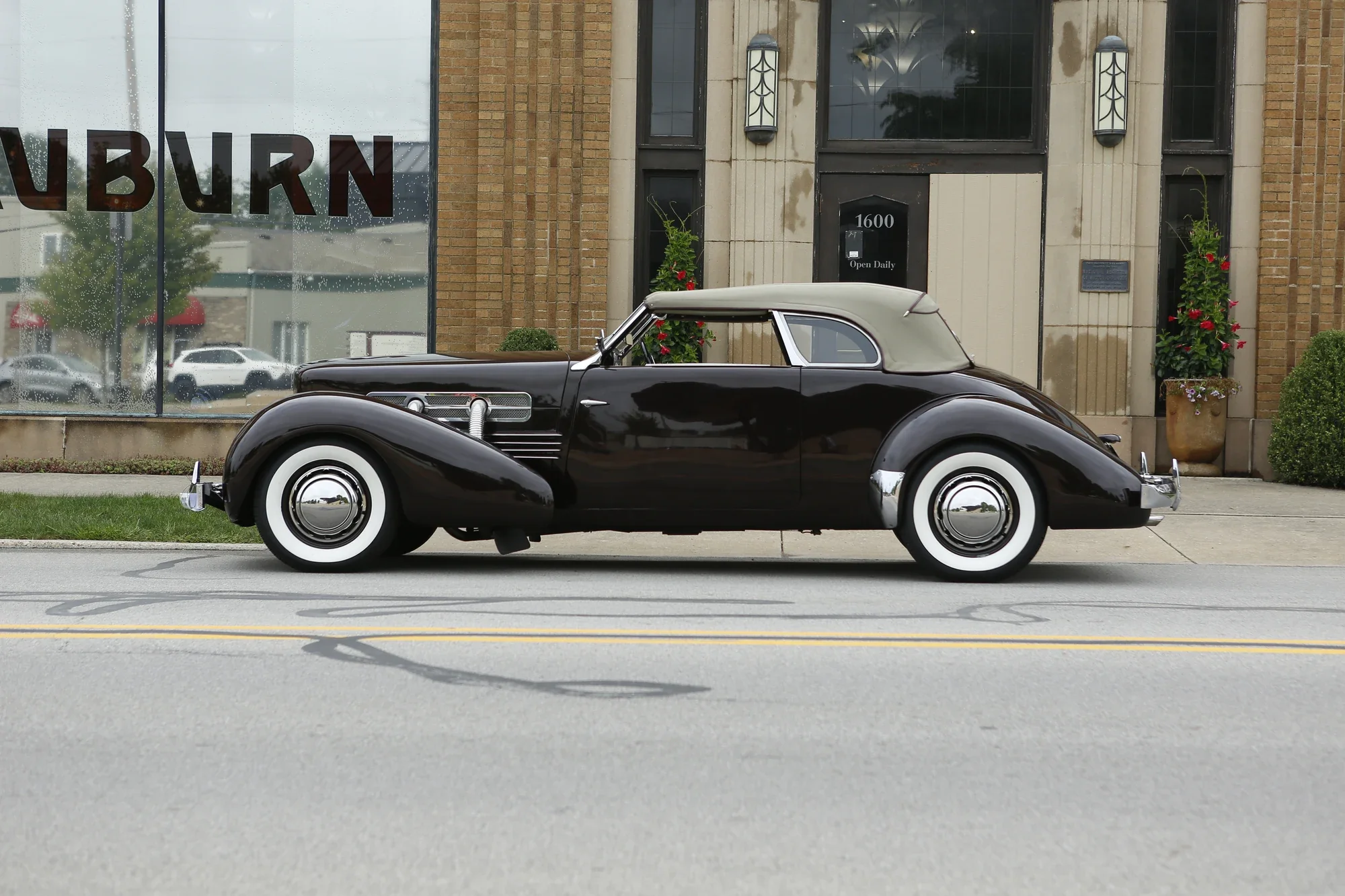 Black vintage automobile with whitewall tires photographed in profile on a city street