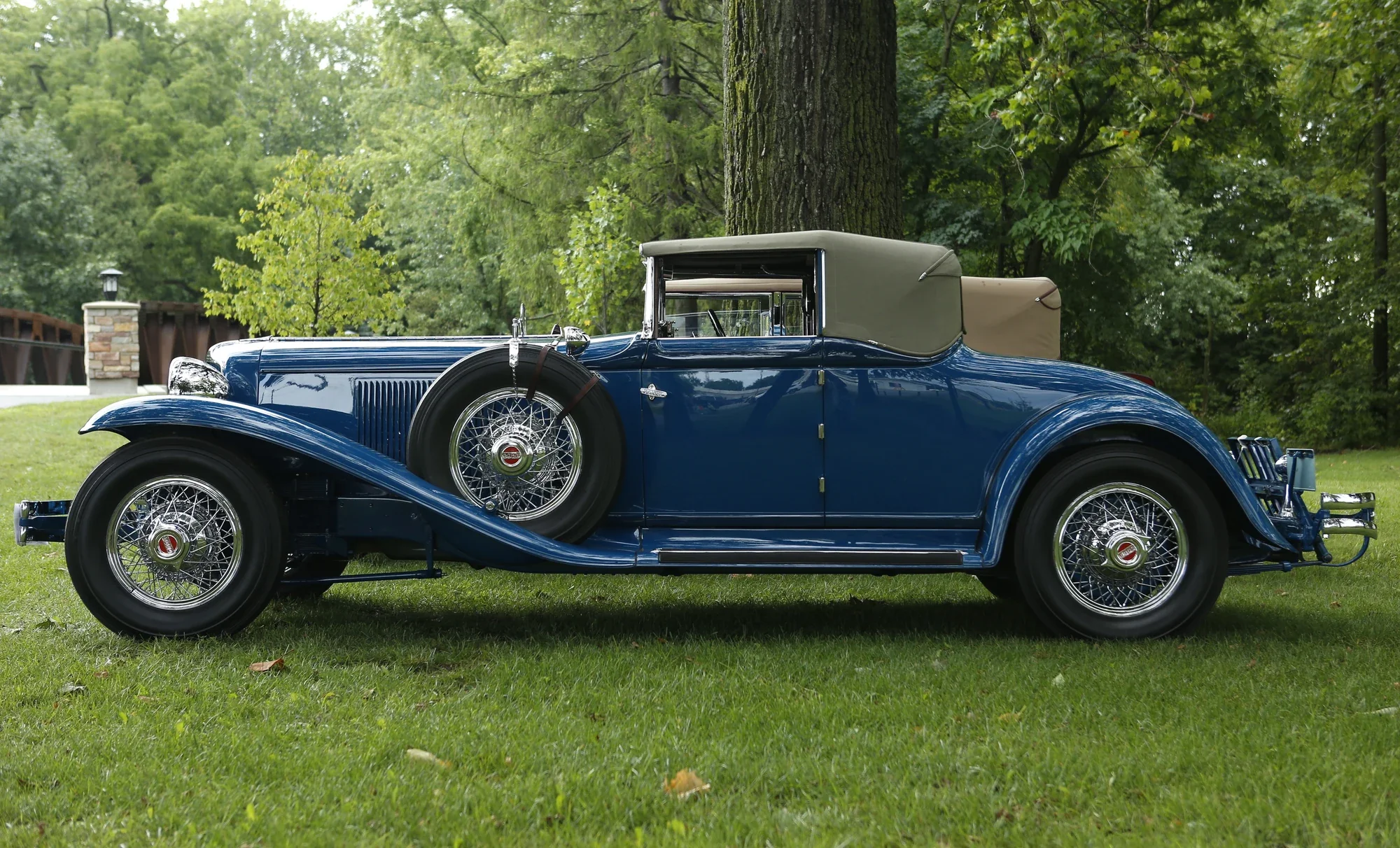 Blue vintage convertible with wire wheels photographed in full profile