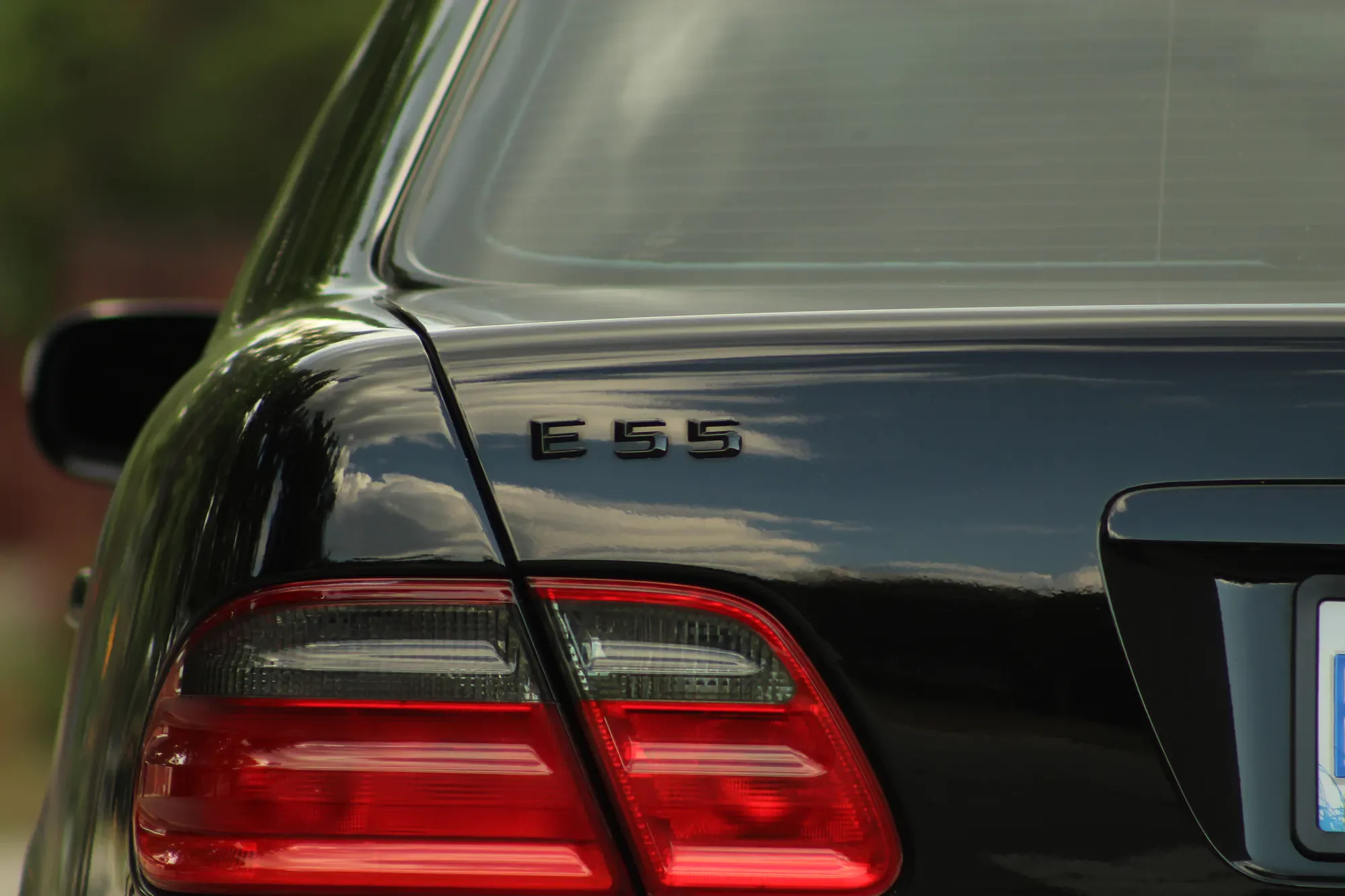 E55 model badge and taillight detail on a black Mercedes-Benz