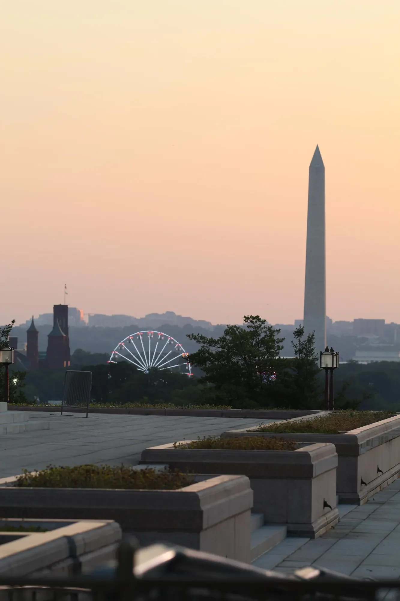 Washington Monument and Ferris wheel in warm sunset light
