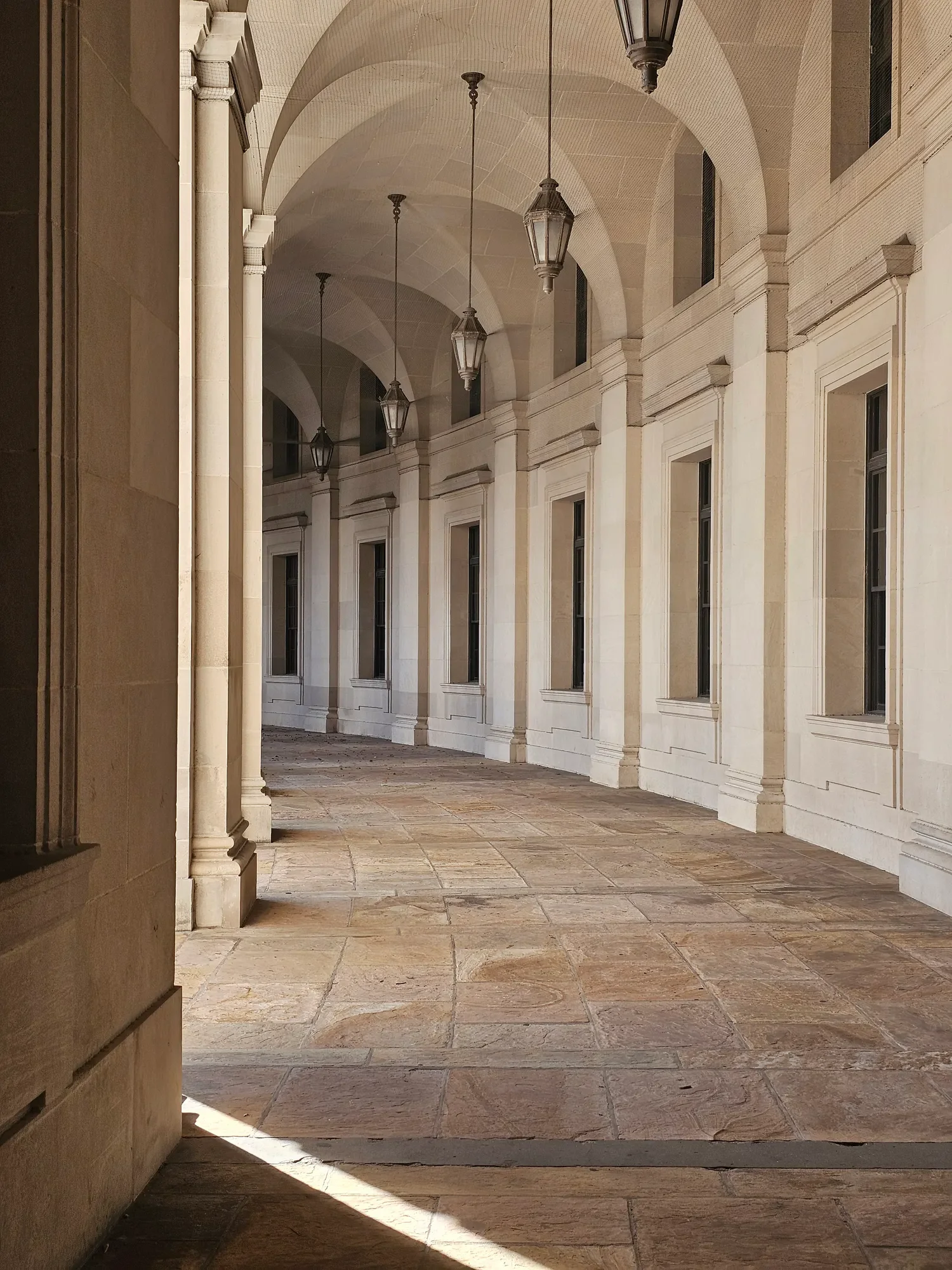 Sunlit stone colonnade with repeating arches