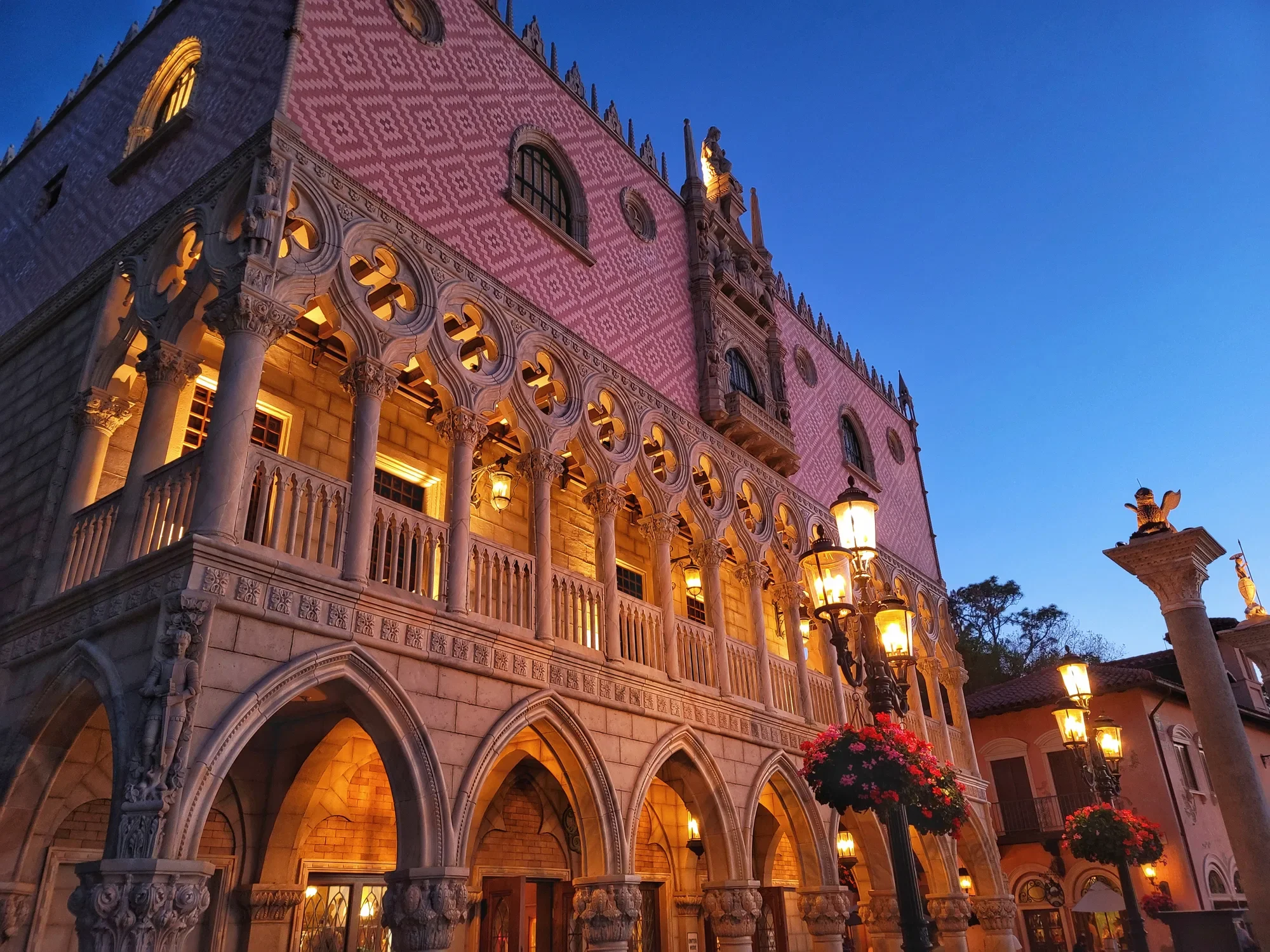 Ornate illuminated façade and arcades beneath a deep blue evening sky