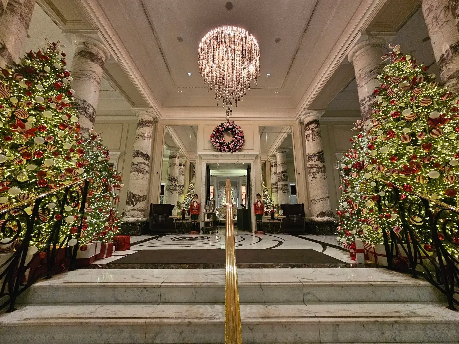 Grand London lobby decorated with Christmas trees and chandeliers