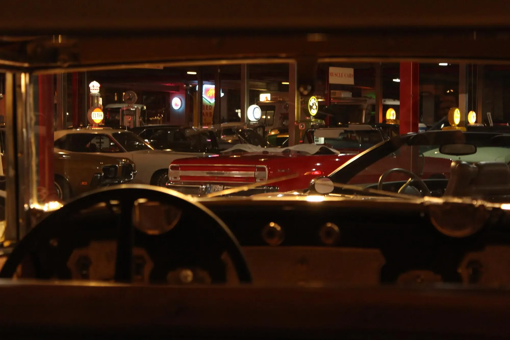Automobiles seen through a layered museum display