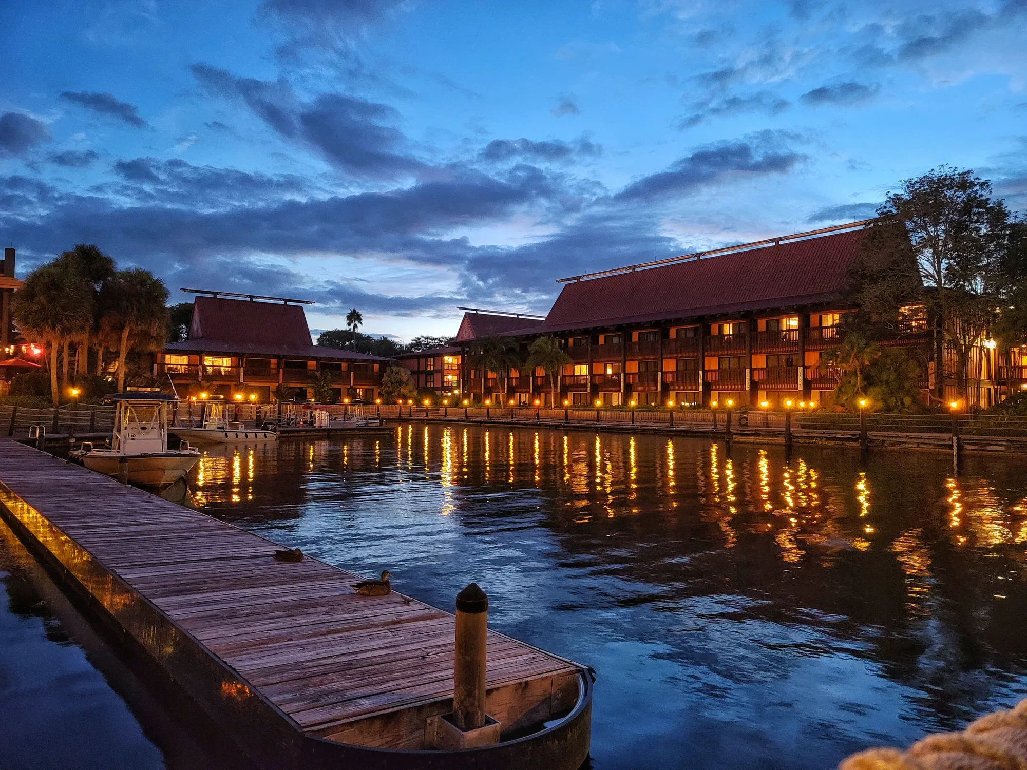 Waterfront buildings and docks reflected in the water at blue hour