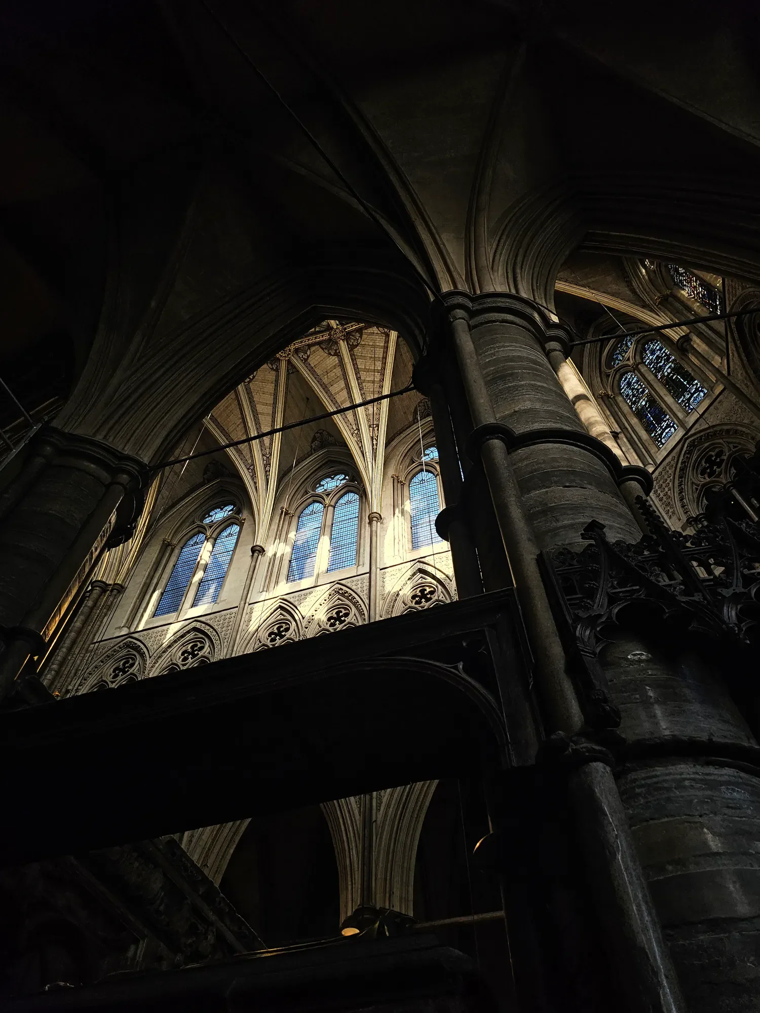 Dark stone columns and ribbed vaulting inside Westminster Abbey