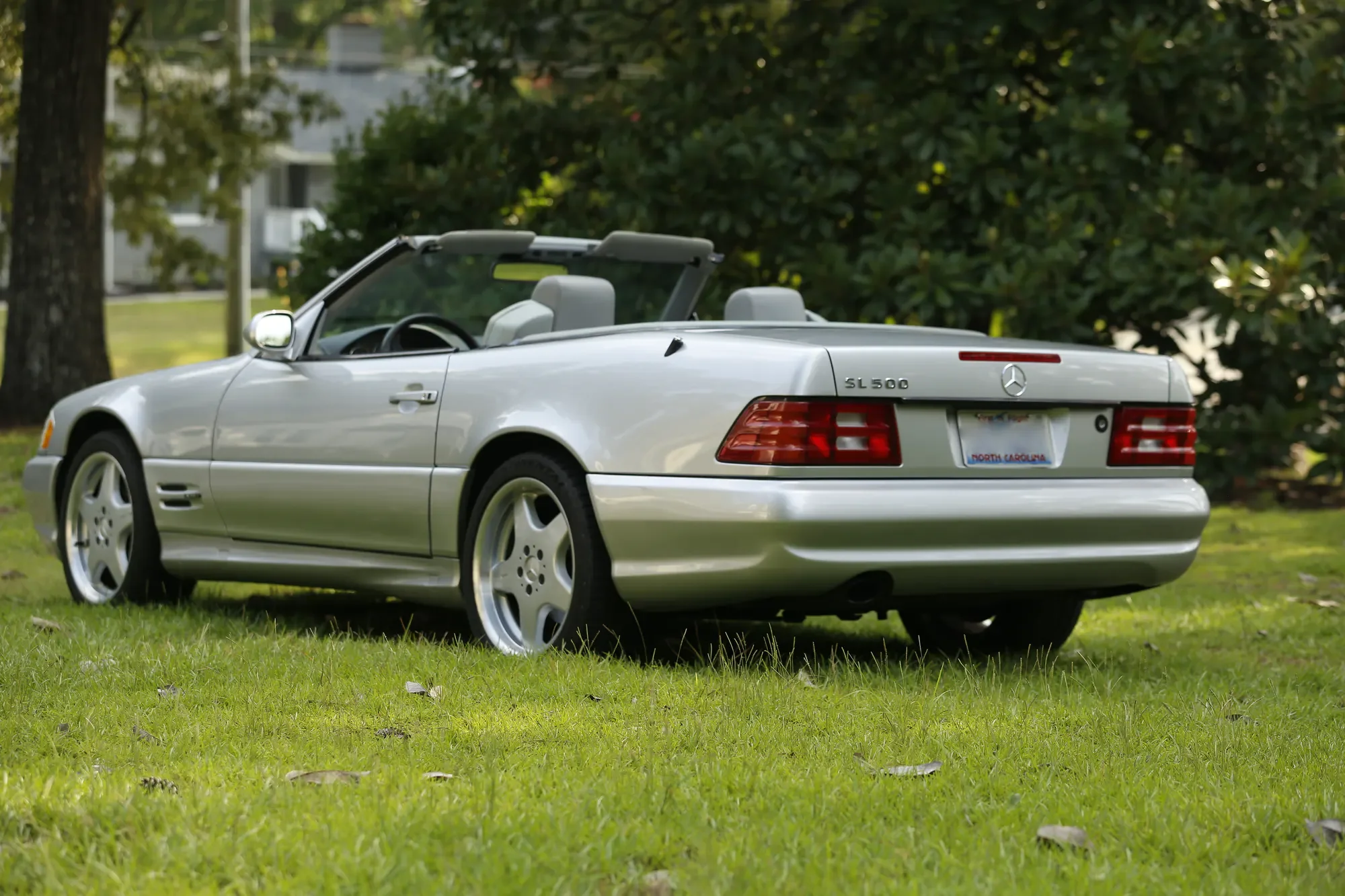 Silver Mercedes-Benz SL500 viewed from the rear in a wooded setting