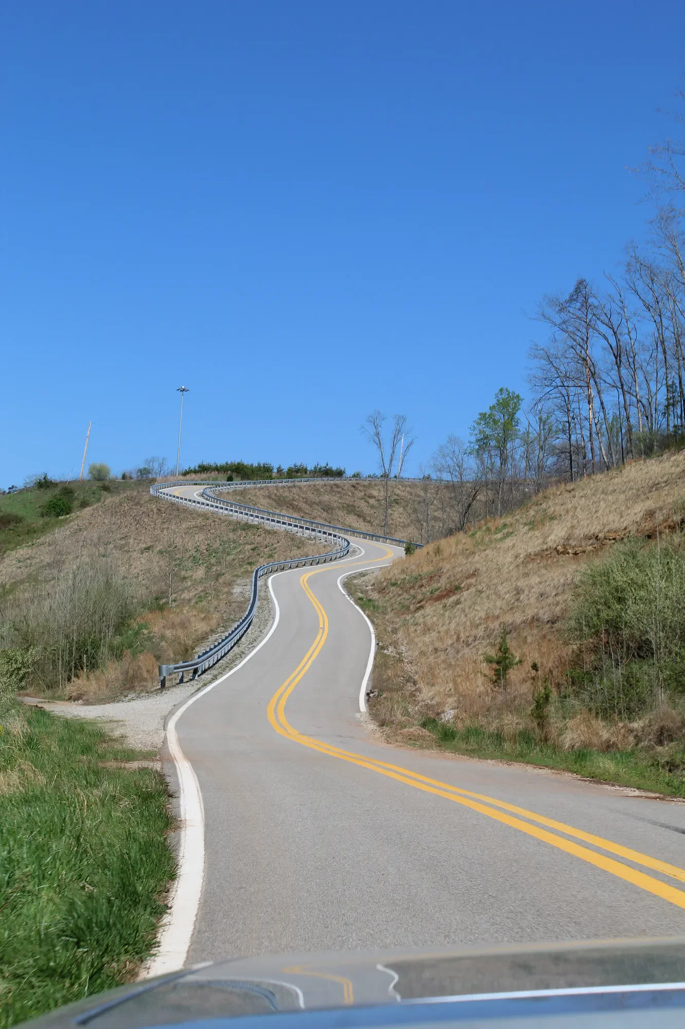 Winding mountain road rising through an open landscape